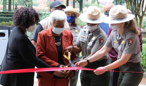 Barbara Harrison, from left, of the King Center; Naomi King, sister-in-law of Martin Luther King Jr.; park superintendent Judy Forte, and Park Ranger Rebecca Karcher help cut the ribbon to a new exhibit honoring Coretta Scott King. (Emil Moffatt/WABE)