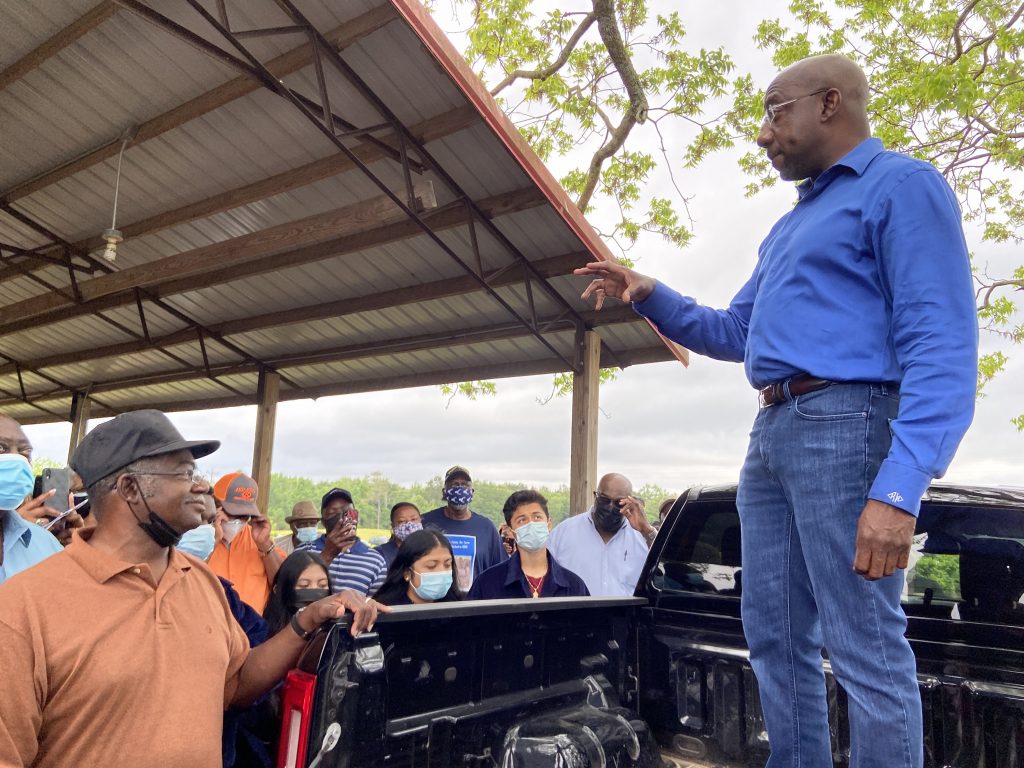 Sen. Raphael Warnock, D-Ga., tells a group of farmers in Byromville, Ga. that debt relief will be coming soon from the USDA. Emma Hurt/WABE