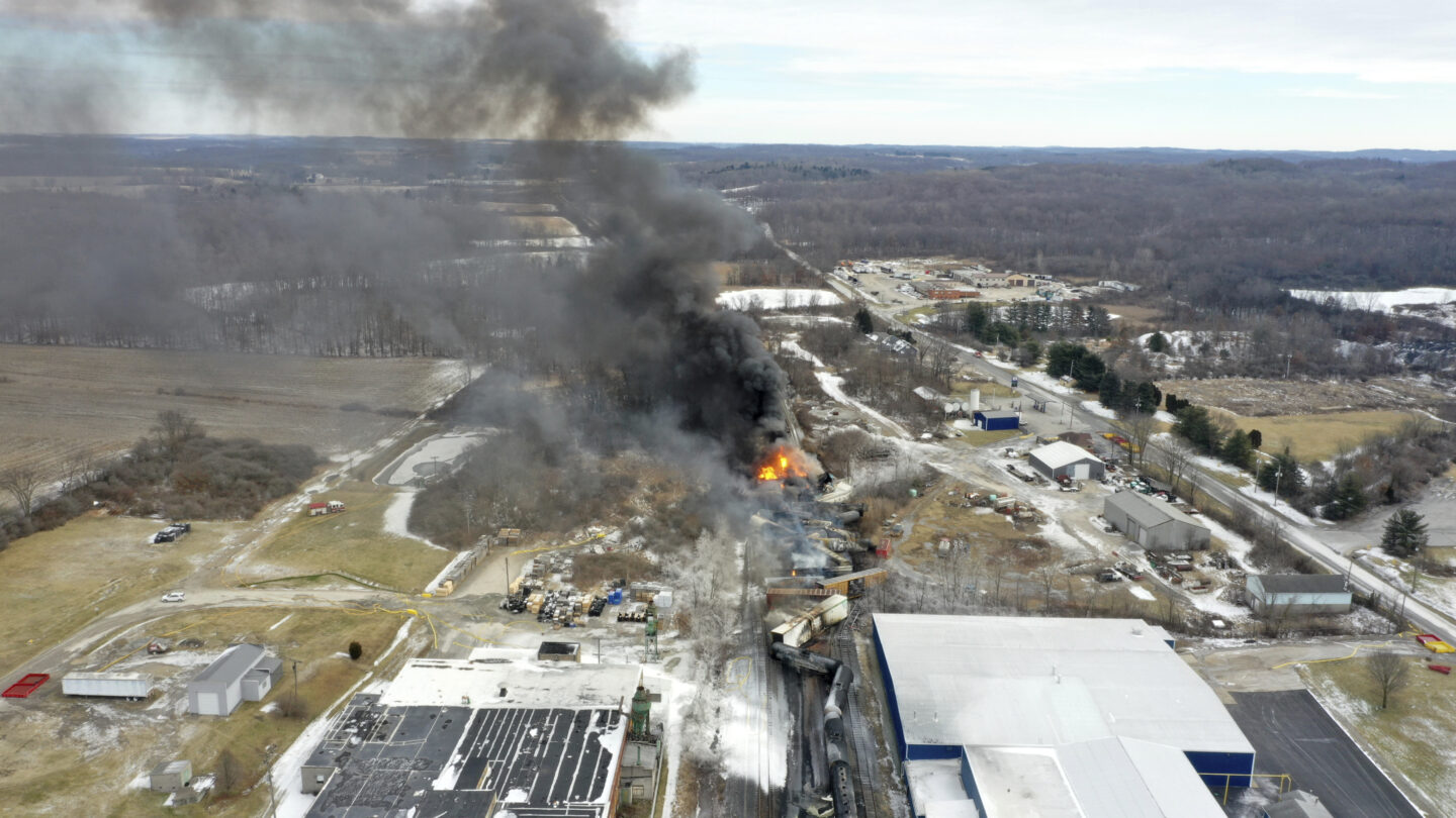 An overhead drone perspective of a train derailment in Ohio, which resulted in a large fire and a plume of smoke rising into the air.