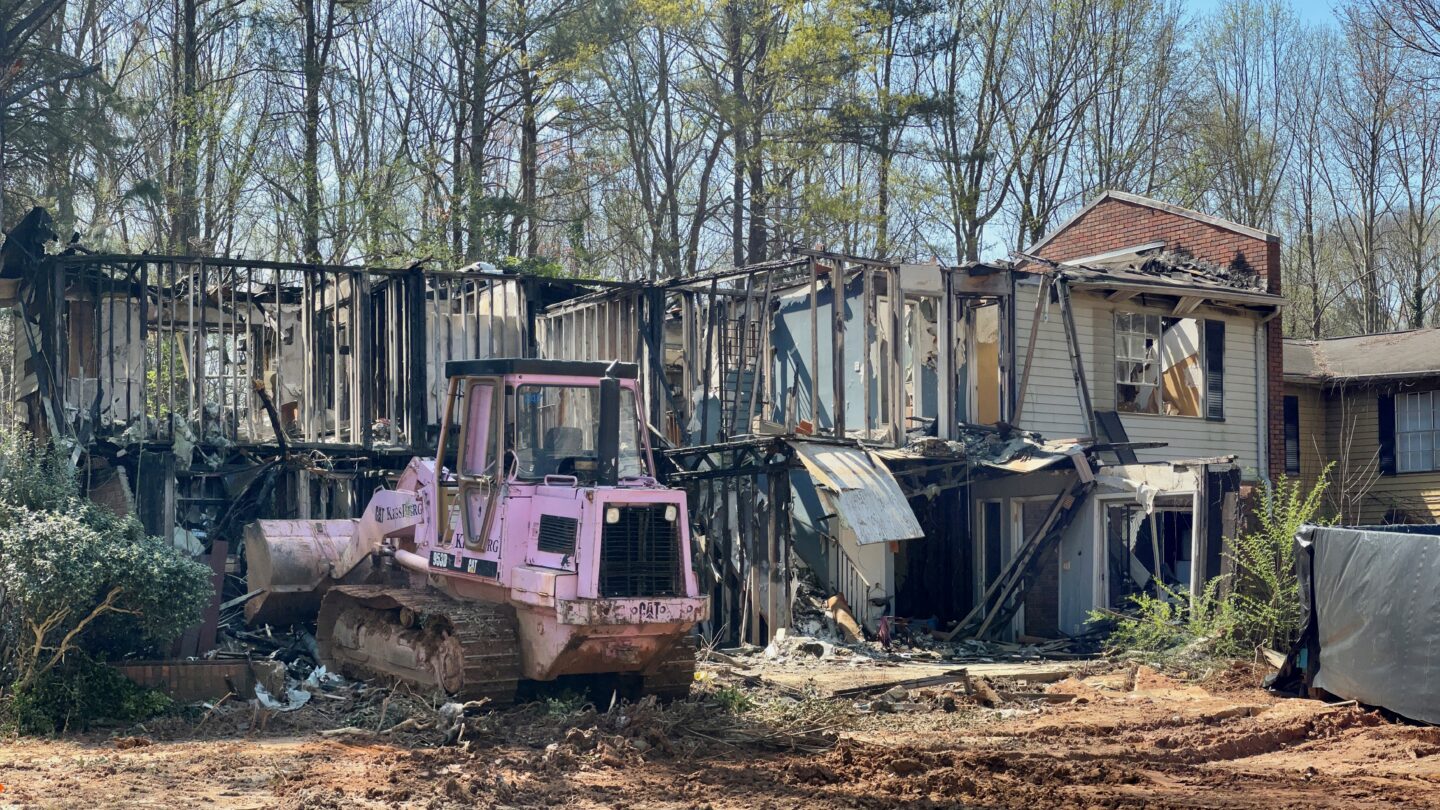 Old tractor in front of demolished house