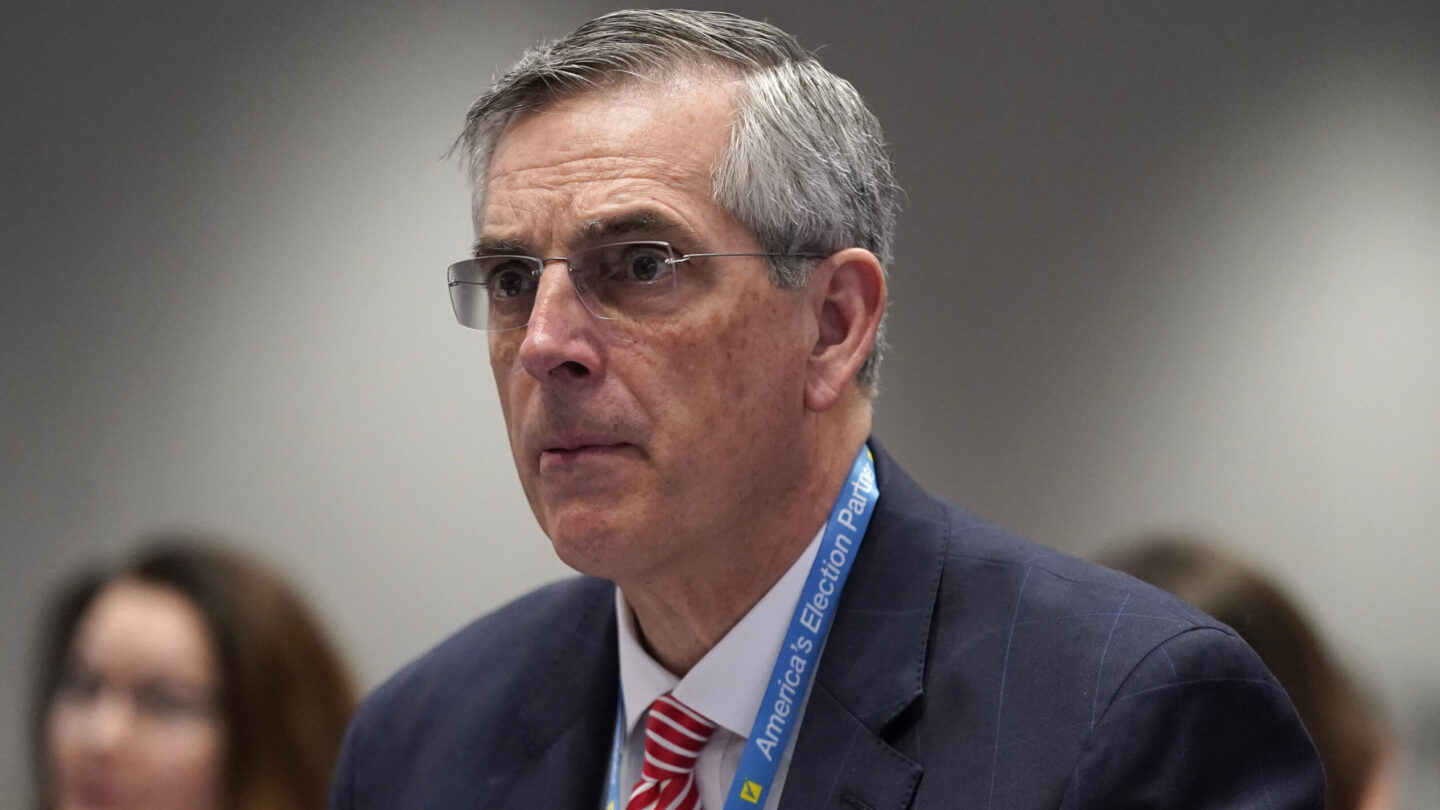 Brad Raffensperger wears a blue lanyard while attending the National Association of Secretaries of State winter meeting in 2023.