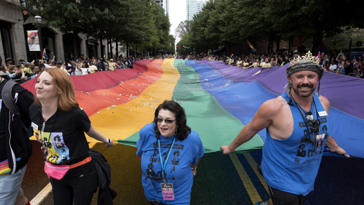 A massive rainbow flag is carried through Midtown Atlanta, collecting donations, during the annual Atlanta Pride Parade in Atlanta, Ga., Sunday, Oct. 13, 2019.