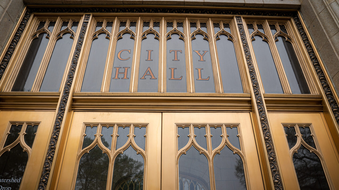 The glass doors of the Atlanta City Hall, trimmed with gold.