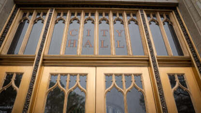 The glass doors of the Atlanta City Hall, trimmed with gold.