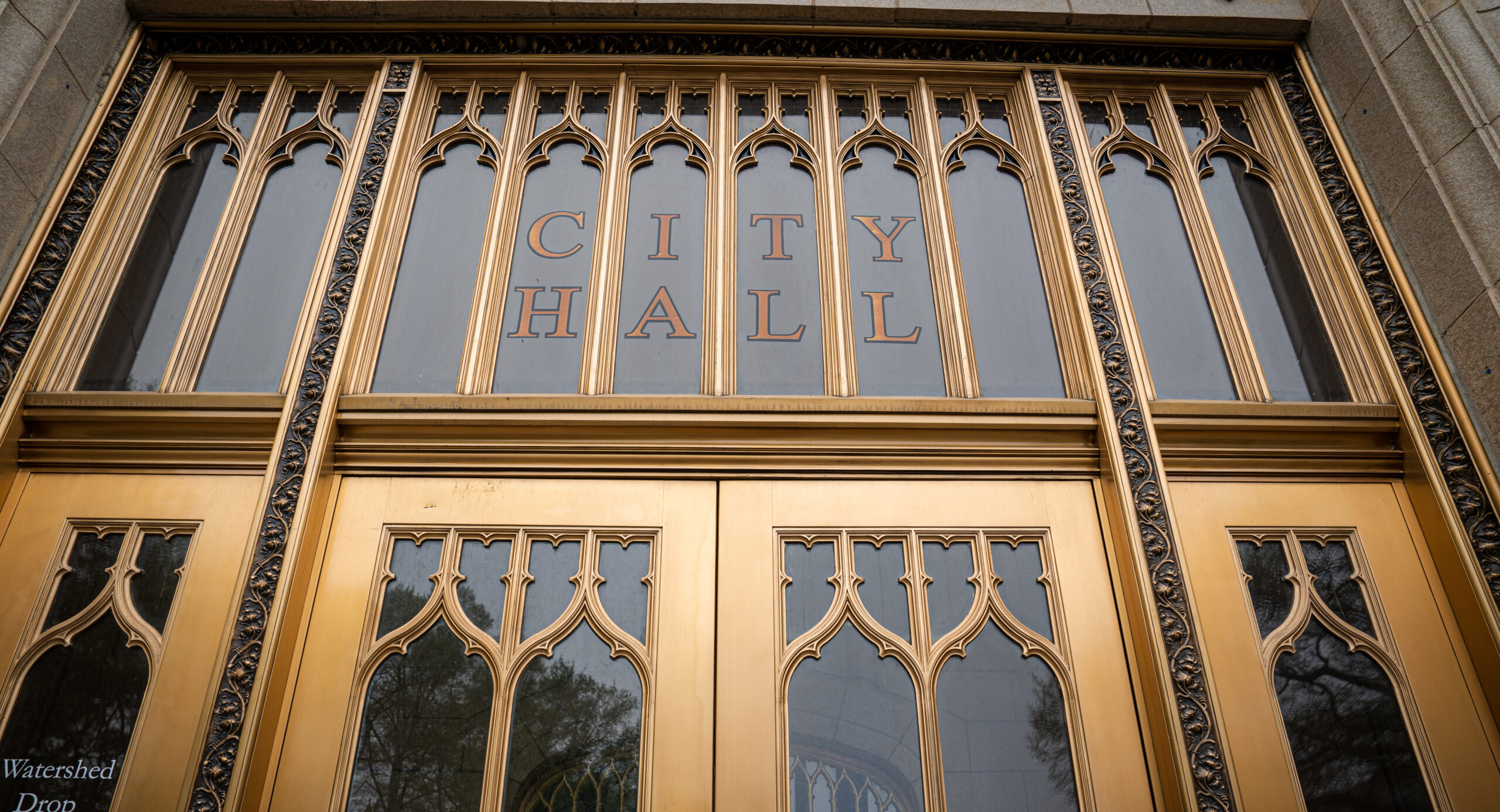 The glass doors of the Atlanta City Hall, trimmed with gold.