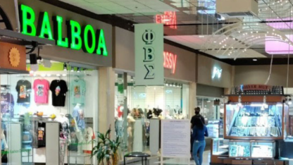 A shop with a neon sign inside Mall West End.