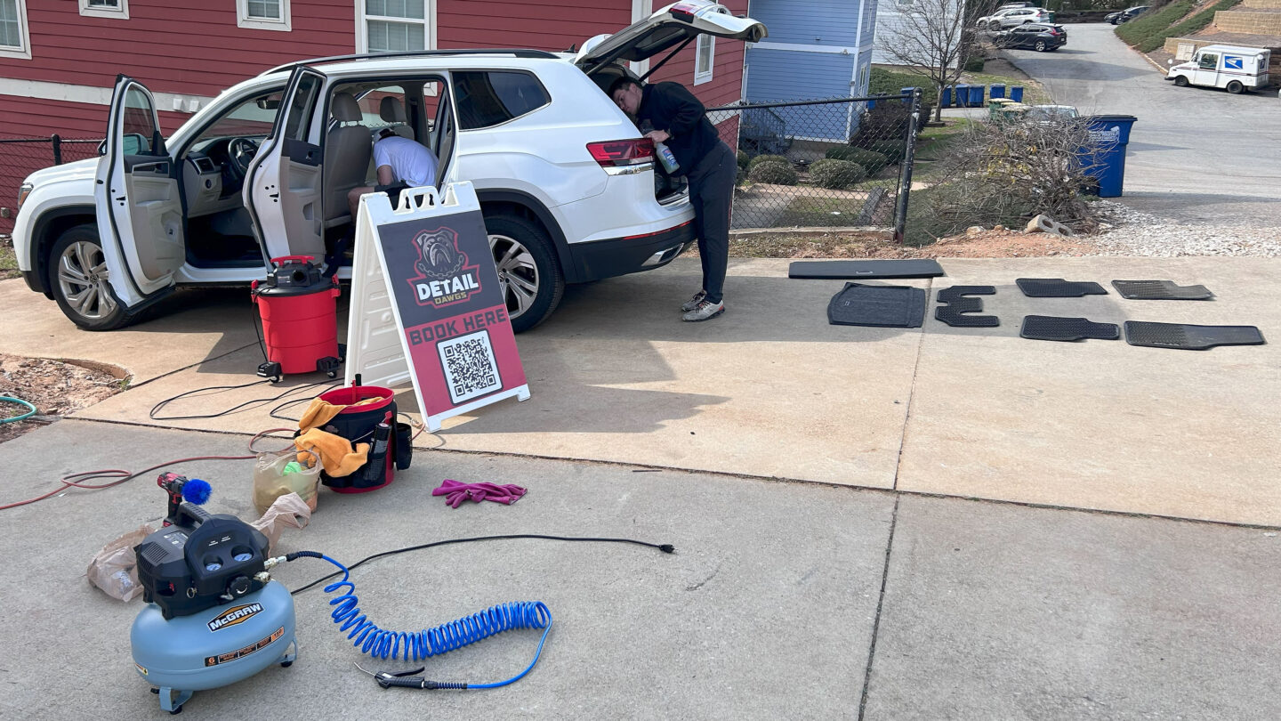 Two guys cleaning a car.