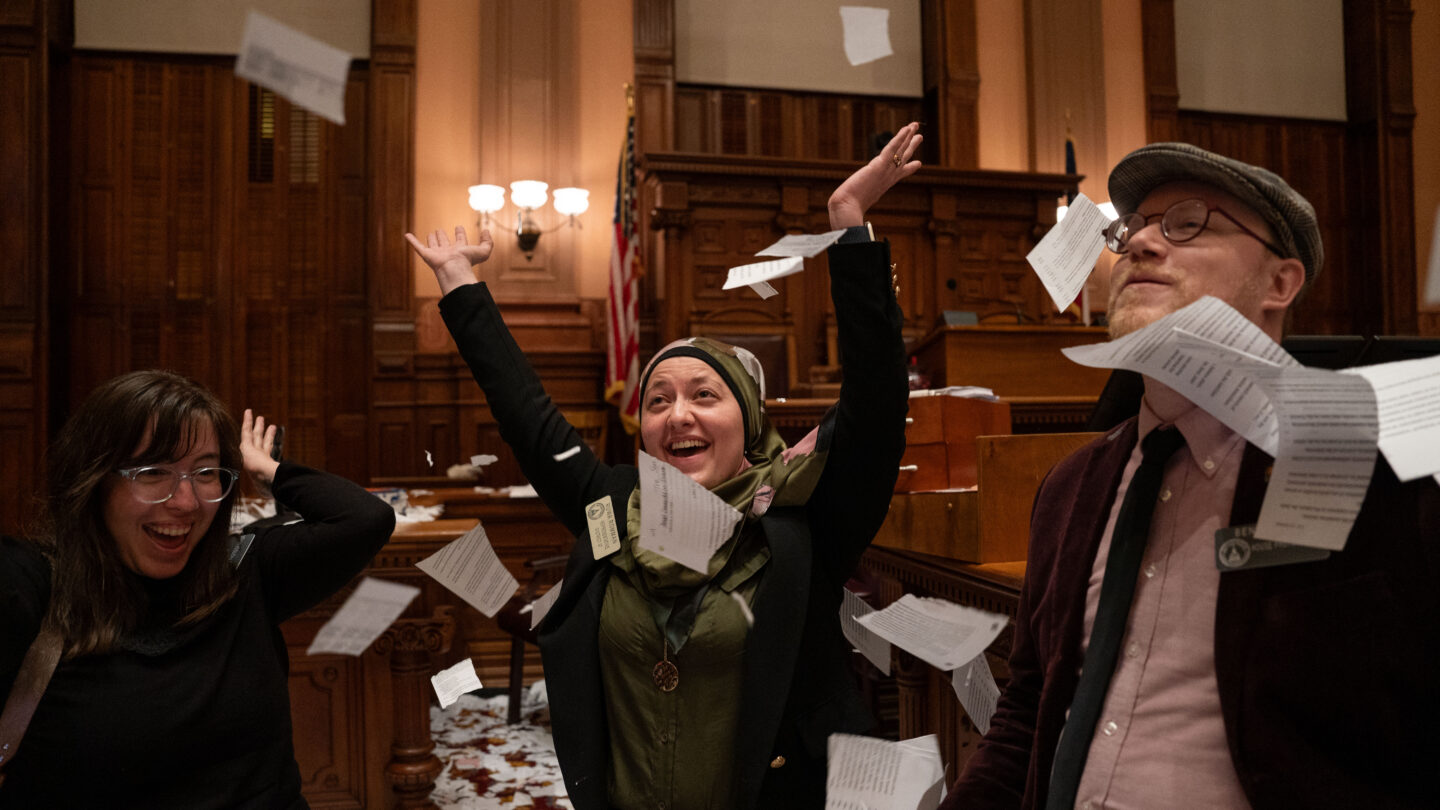 Happy people throwing papers in air