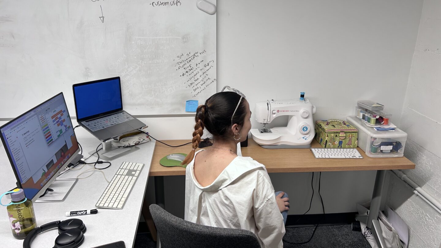 Young woman at computers and sewing machine