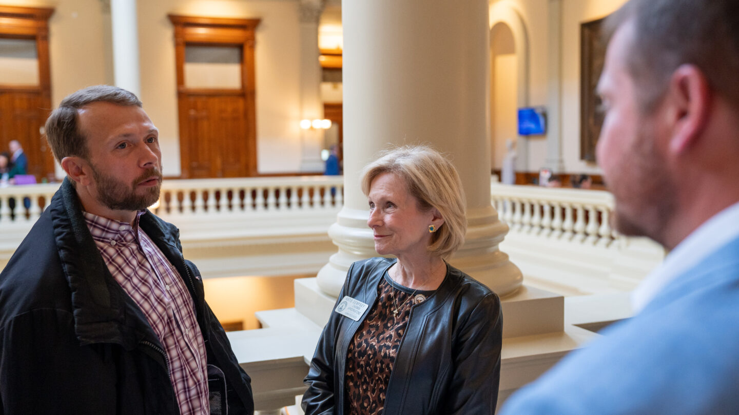 Man talking with two legislators