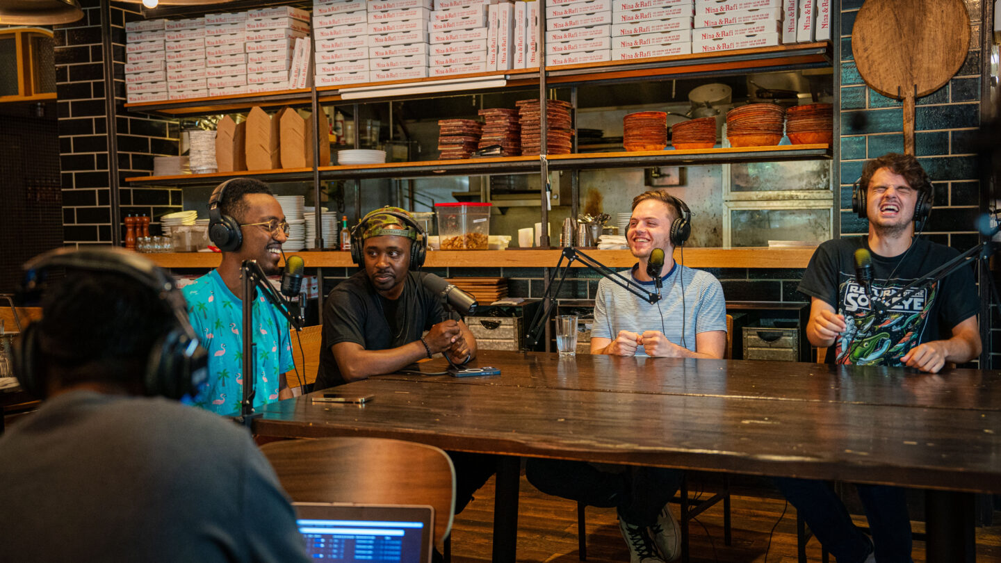 Young men laughing while recording podcast.