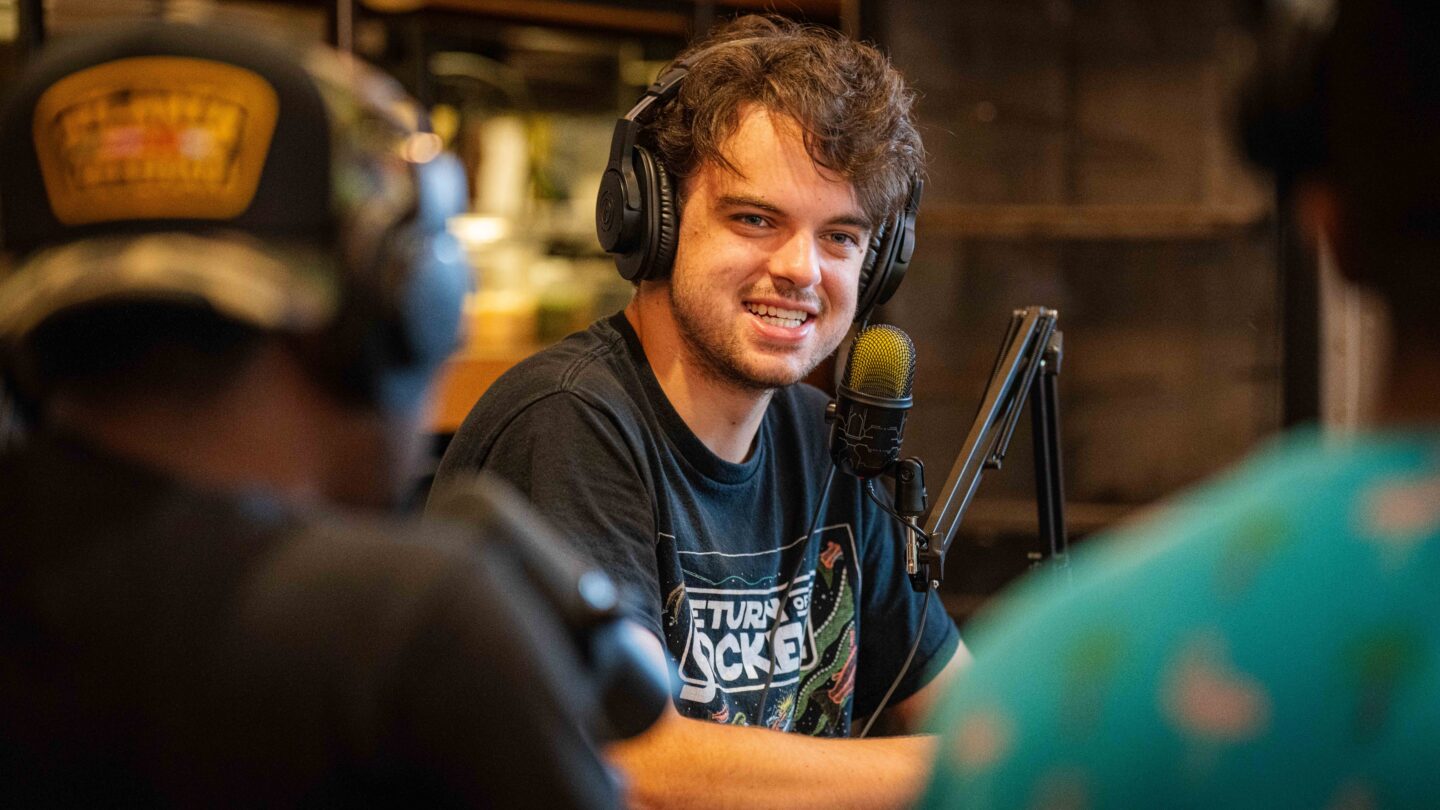 Young man with headphones recording a podcast with friends