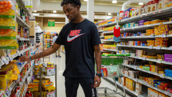 Young man selecting food in grocery store isle