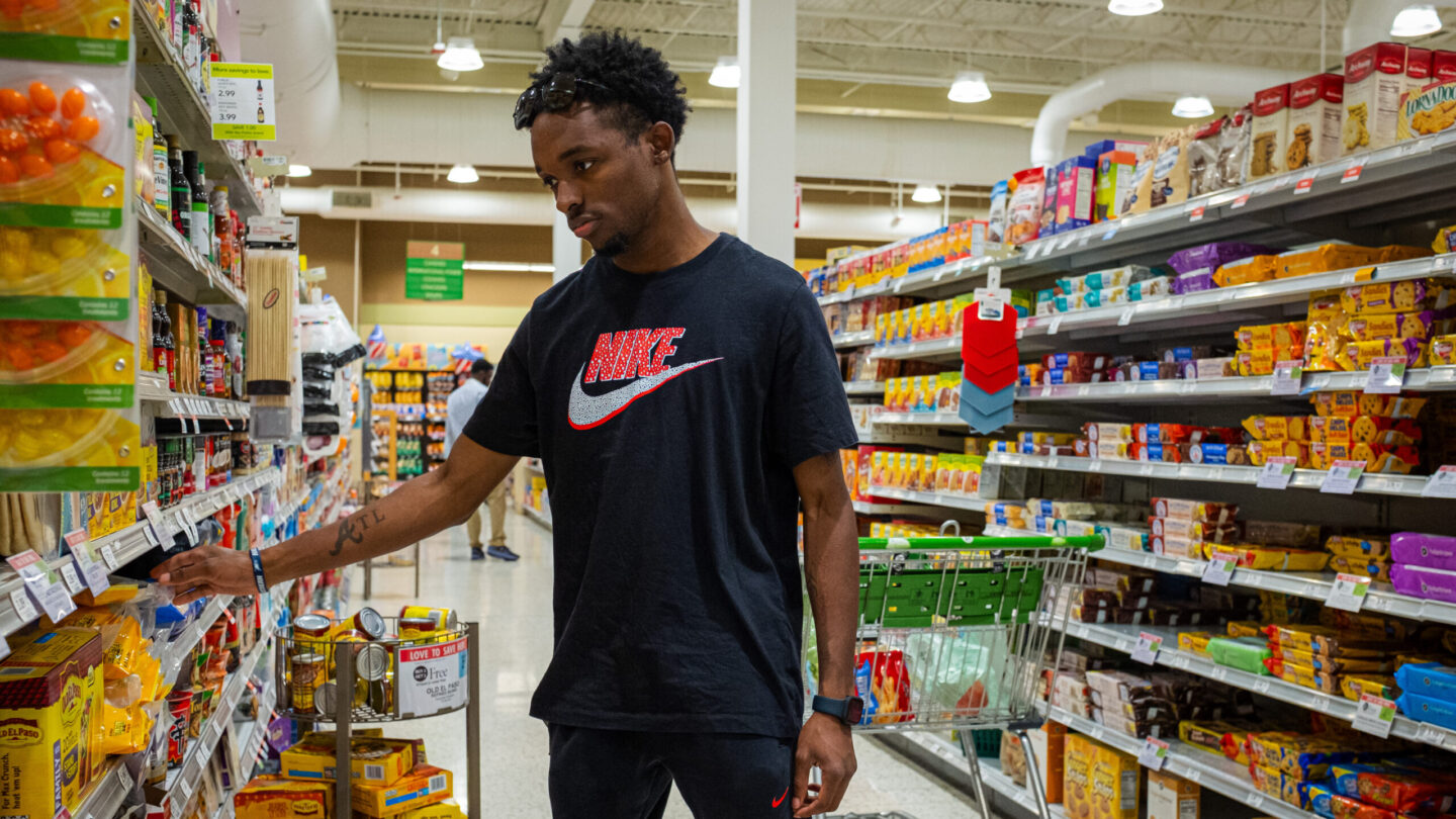 Young man selecting food in grocery store isle