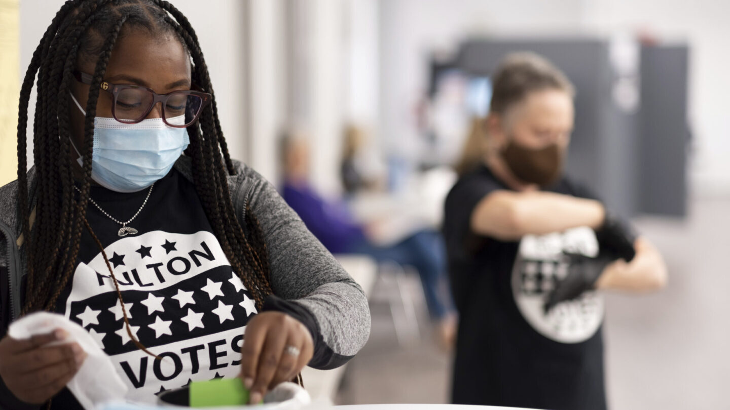 Young female poll worker cleaning card