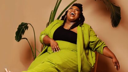 poet aurielle marie laughing in a chair