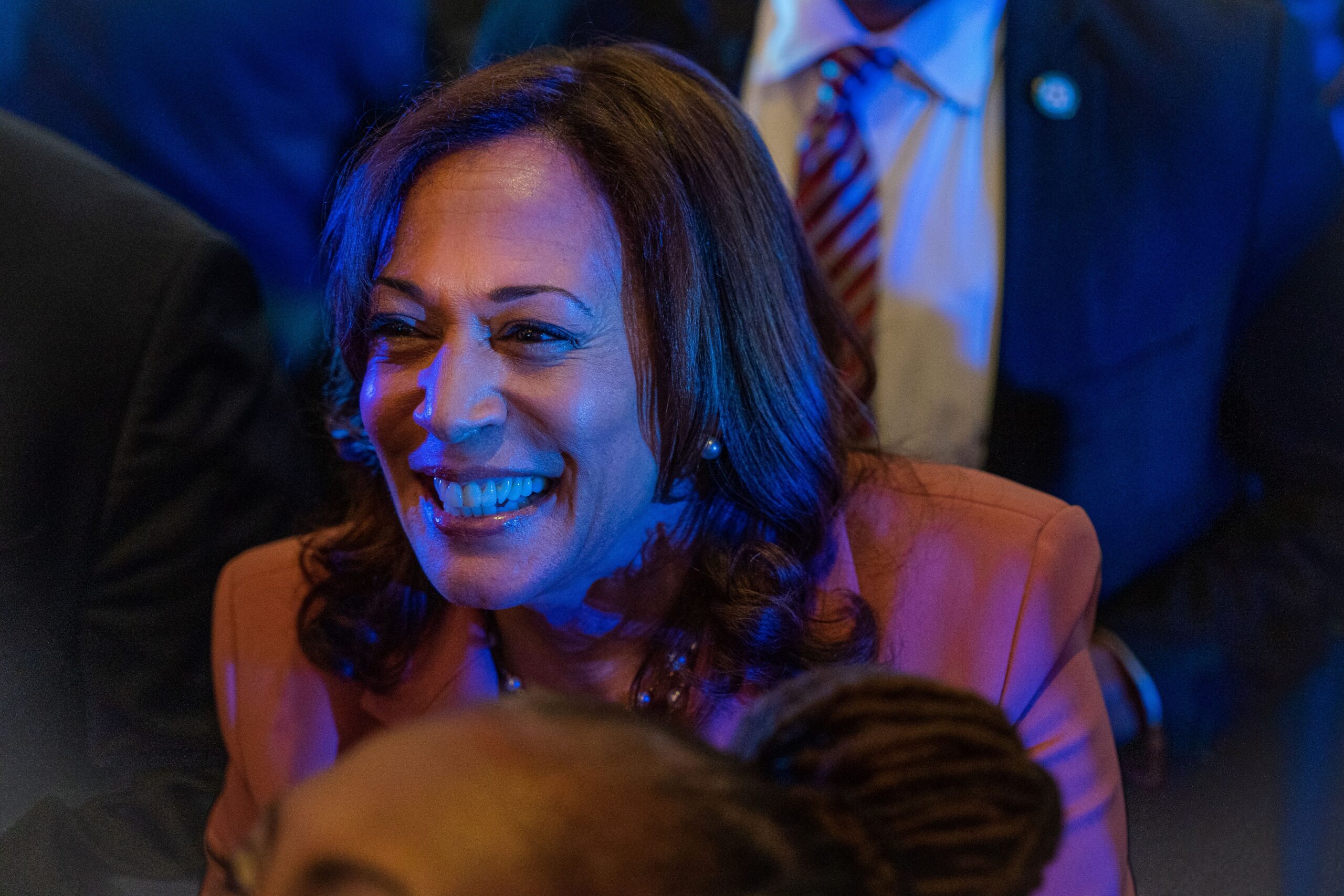 Kamala Harris smiles as a blue light illuminates her at a campaign stop in May 2023.