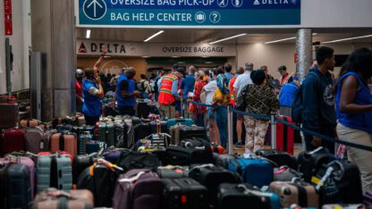 Luggage covers the floor of baggage claim at Atlanta's Hartfield-Jackson Airport as Delta employees try to reunite passengers with their belongings.