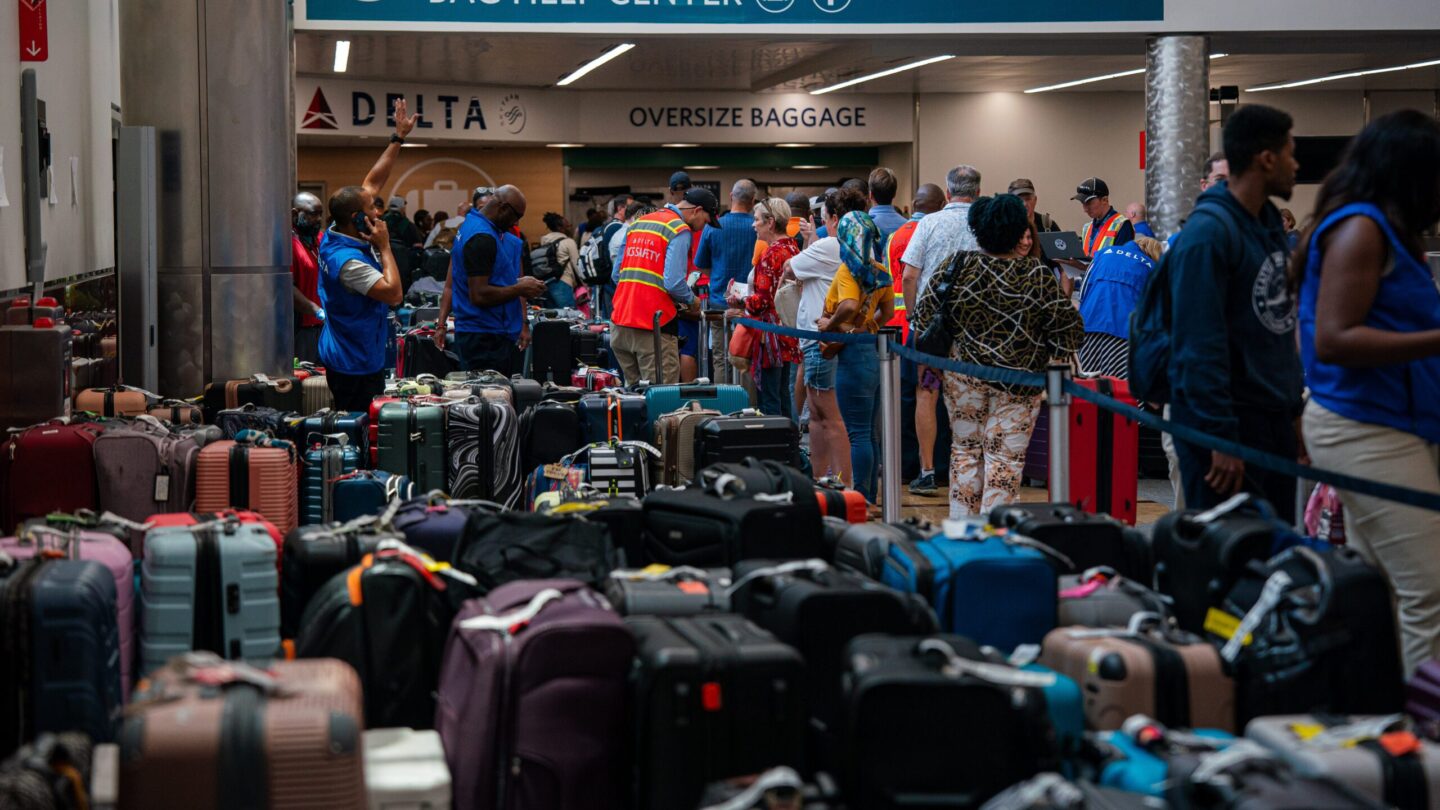 Luggage covers the floor of baggage claim at Atlanta's Hartfield-Jackson Airport as Delta employees try to reunite passengers with their belongings.