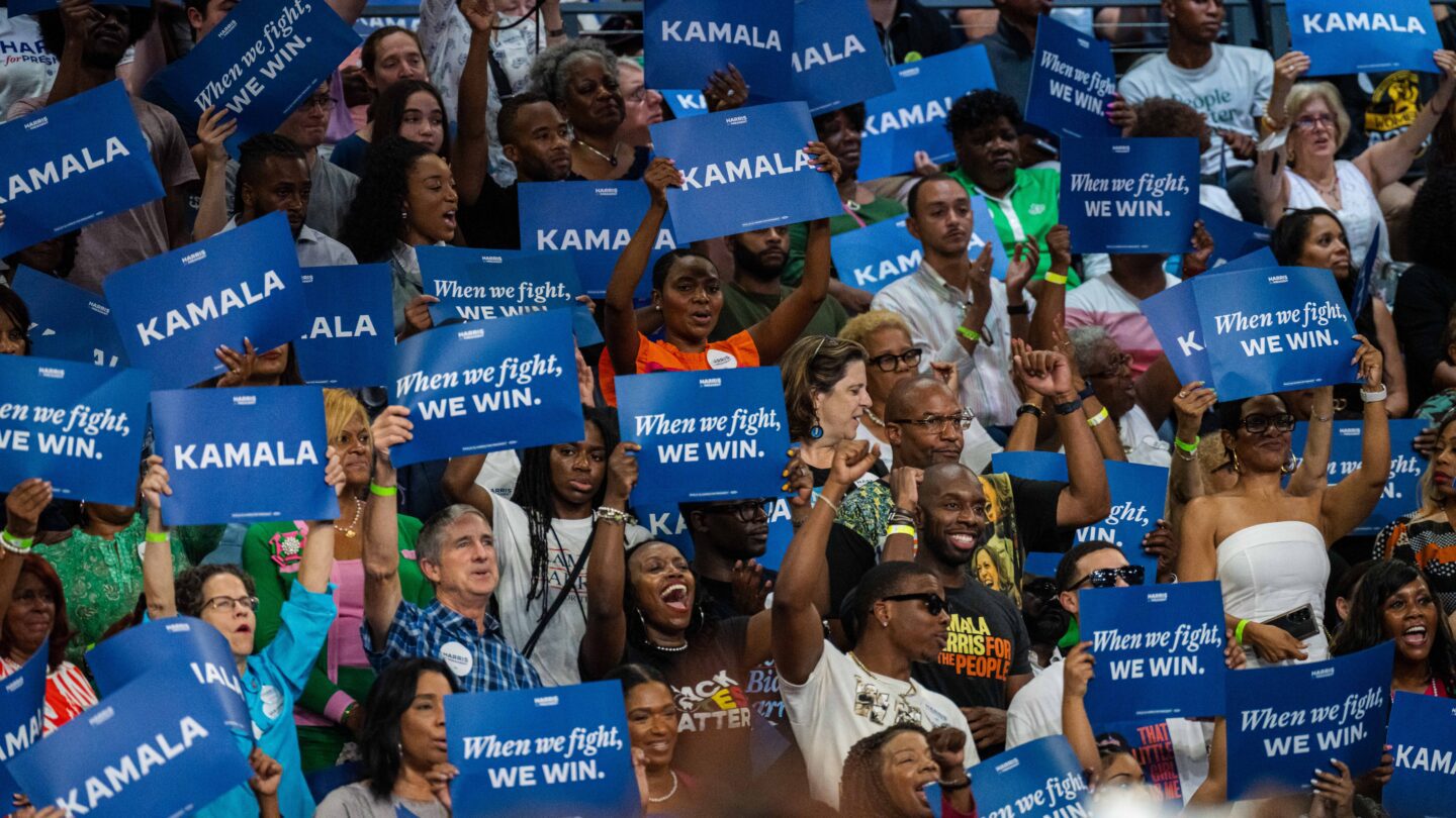 A crowd of supporters at Kamala Harris's July 30 Atlanta rally wave blue signs.