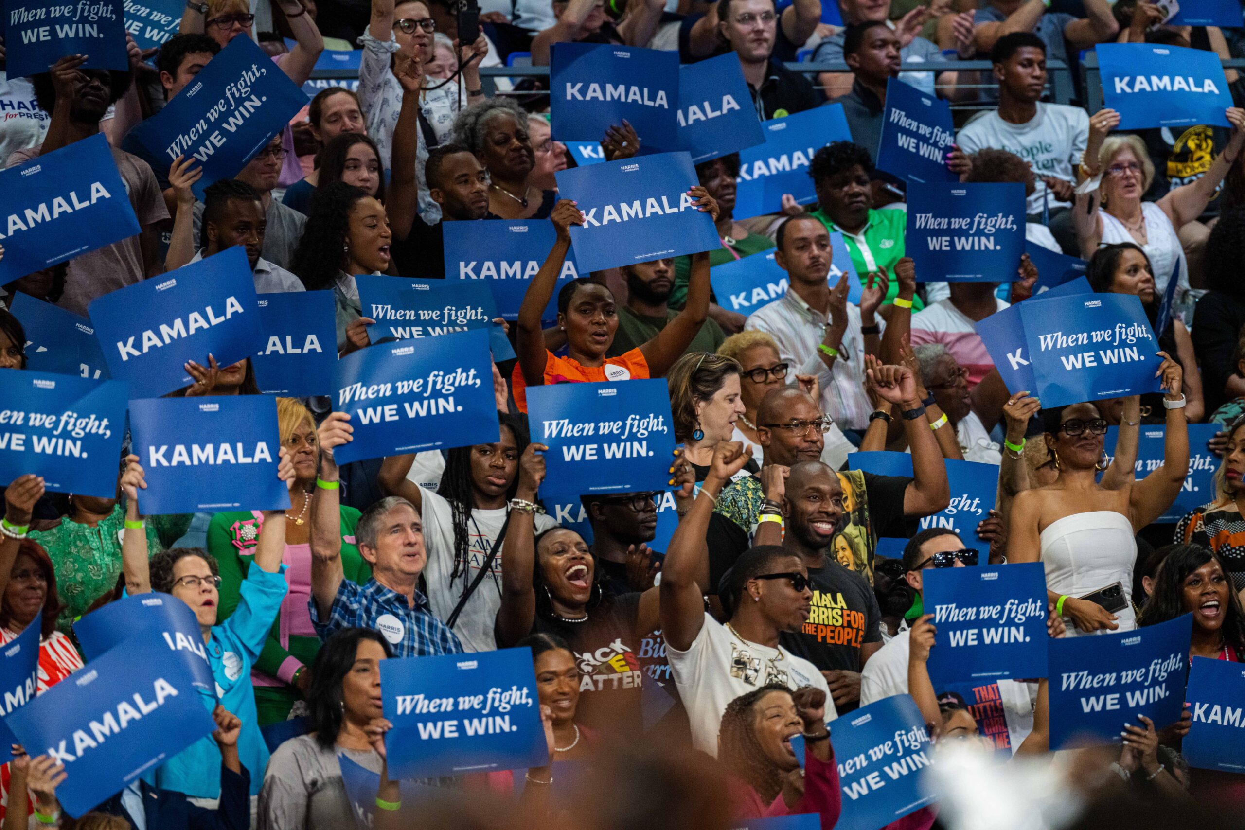 A crowd of supporters at Kamala Harris's July 30 Atlanta rally wave blue signs.