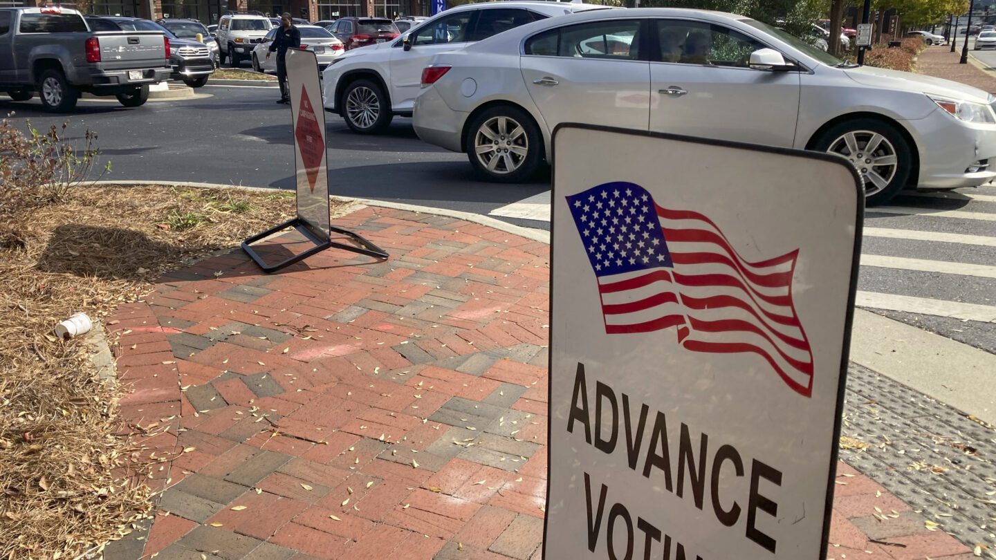 A sign showing the way for voters stands outside a Cobb County voting building during the first day of early voting, Monday, Oct. 17, 2022, in Marietta, Georgia.