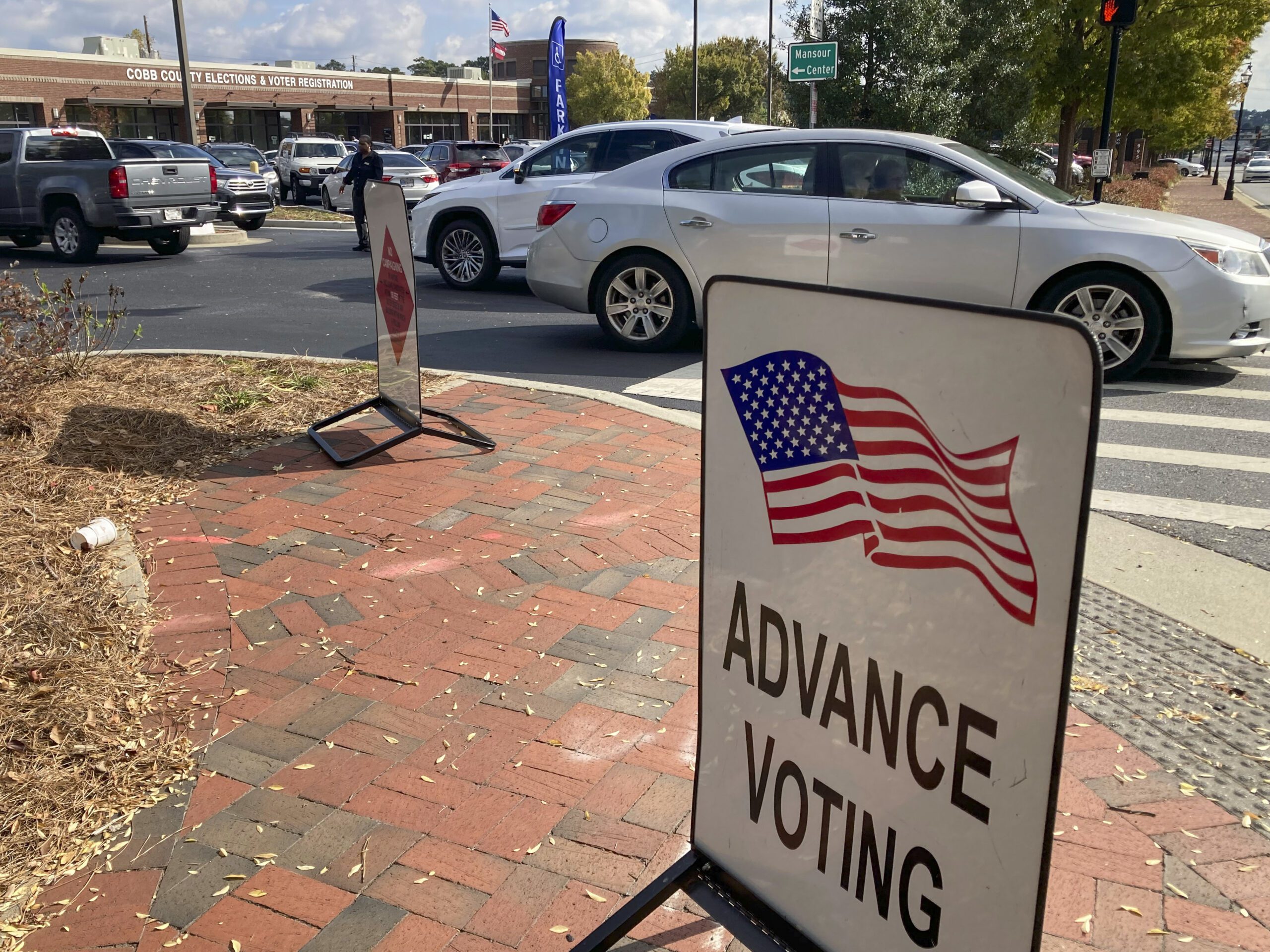 A sign showing the way for voters stands outside a Cobb County voting building during the first day of early voting, Monday, Oct. 17, 2022, in Marietta, Georgia.