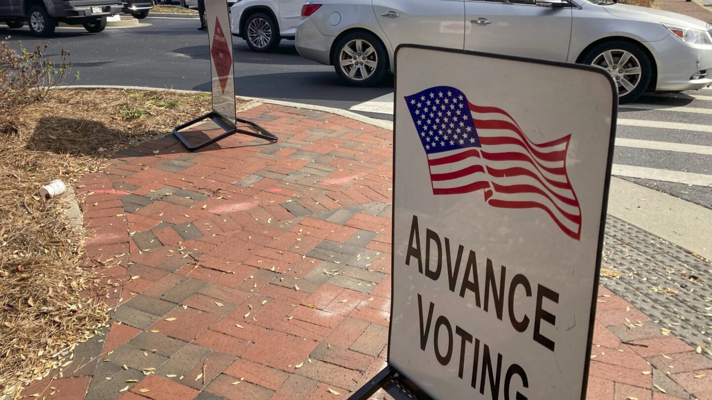 A sign showing the way for voters stands outside a Cobb County voting building during the first day of early voting, Monday, Oct. 17, 2022, in Marietta, Georgia.