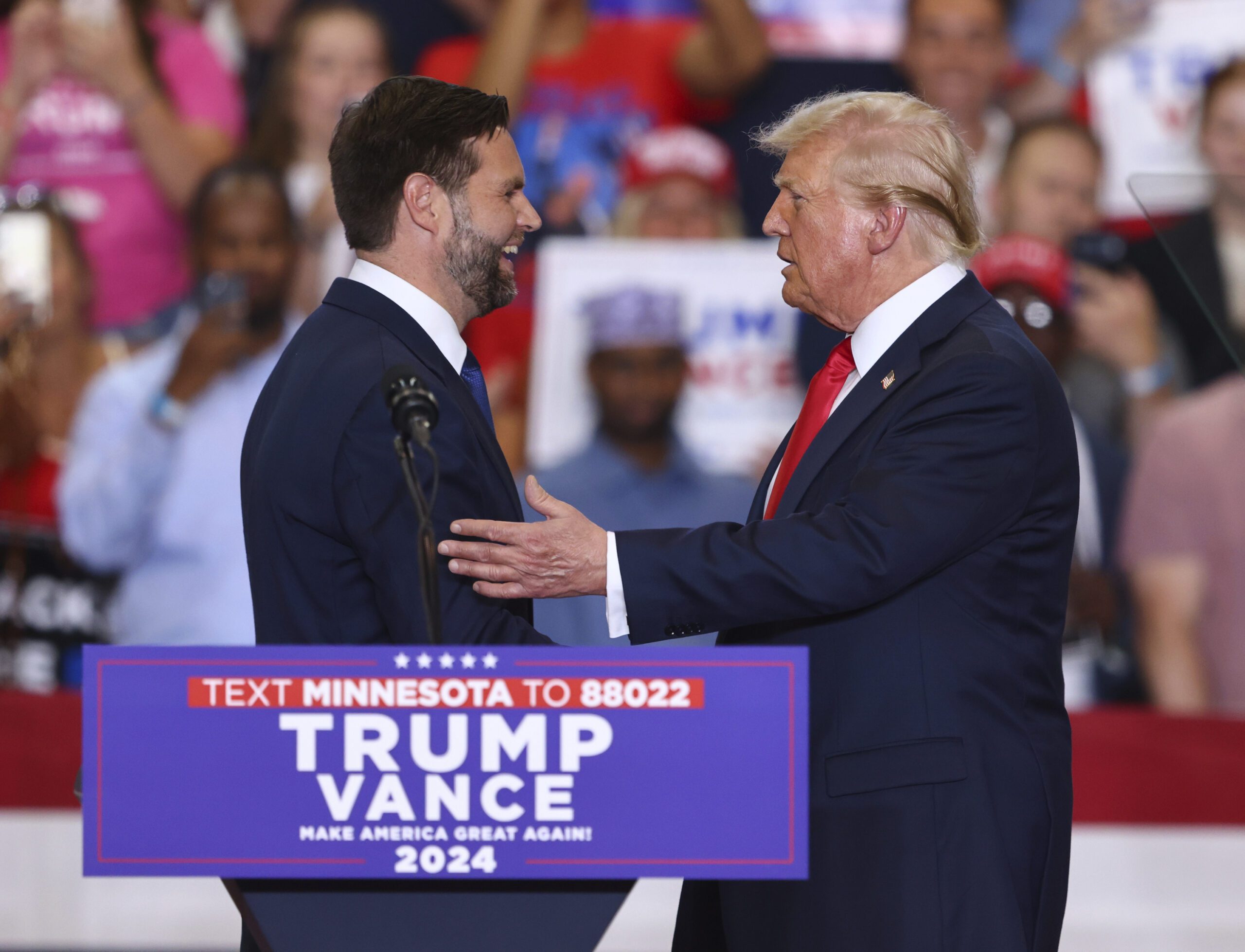 Republican presidential candidate former President Donald Trump and Republican vice presidential candidate Sen. JD Vance, R-Ohio, greet each other at a campaign rally, Saturday, July 27, 2024, in St. Cloud, Minn.