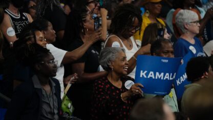 Rallygoers at Kamala Harris' campaign rally in Atlanta hold up signs and cheer.