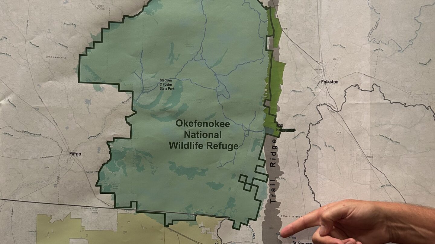 A hand points to a general area on a gray strip designating Trail Ridge on a map of the Okefenokee National Wildlife Refuge.