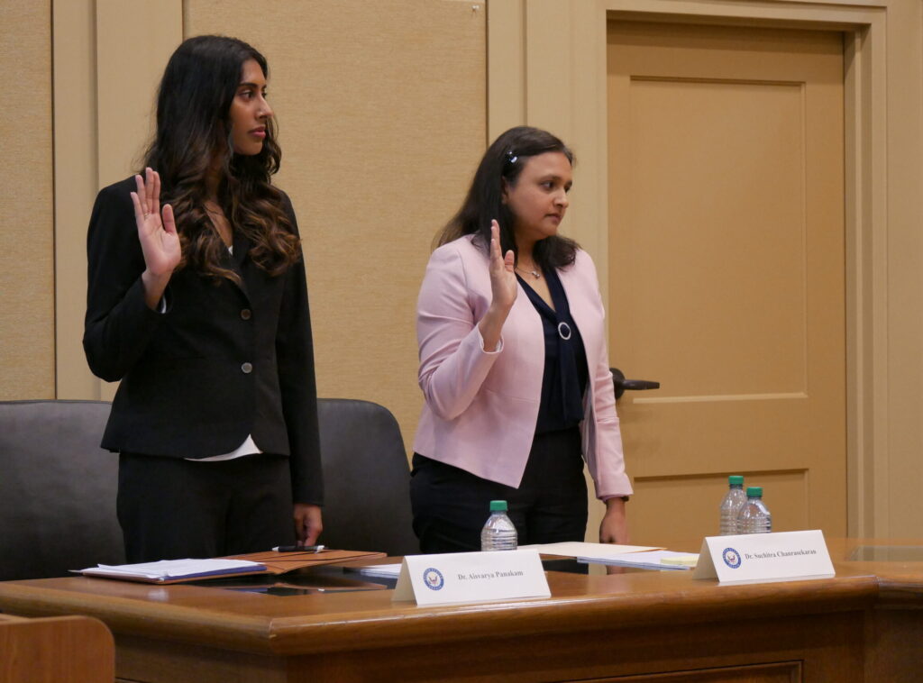 Dr. Aisvarya Panakam stands to the left and Dr. Suchitra Chandrasekaran stand on the right as they are sworn in Tuesday at a Senate subcommittee field hearing at Decatur City Hall.