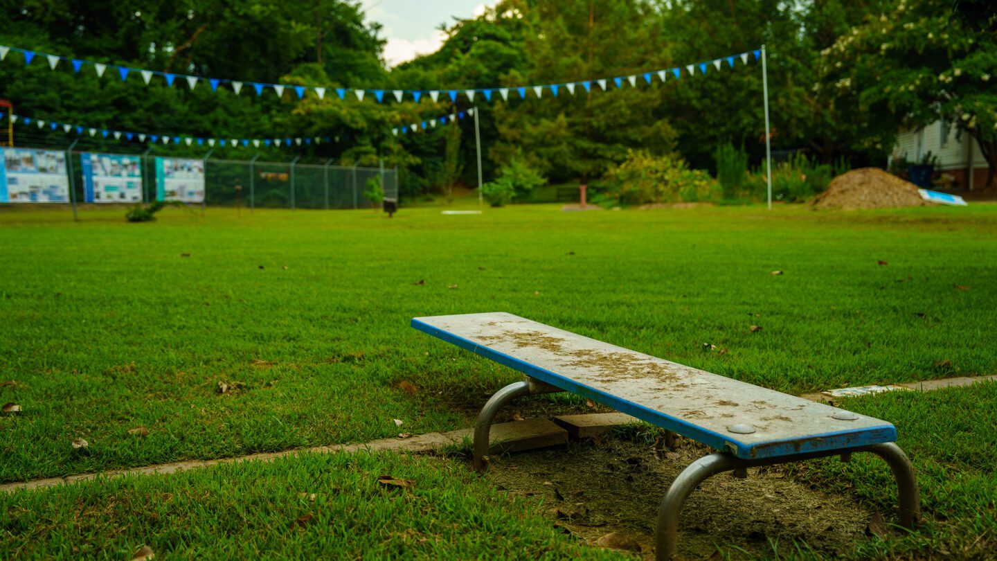 An old diving board sits on top of a grassy field where a segregated pool in East Point once existed.