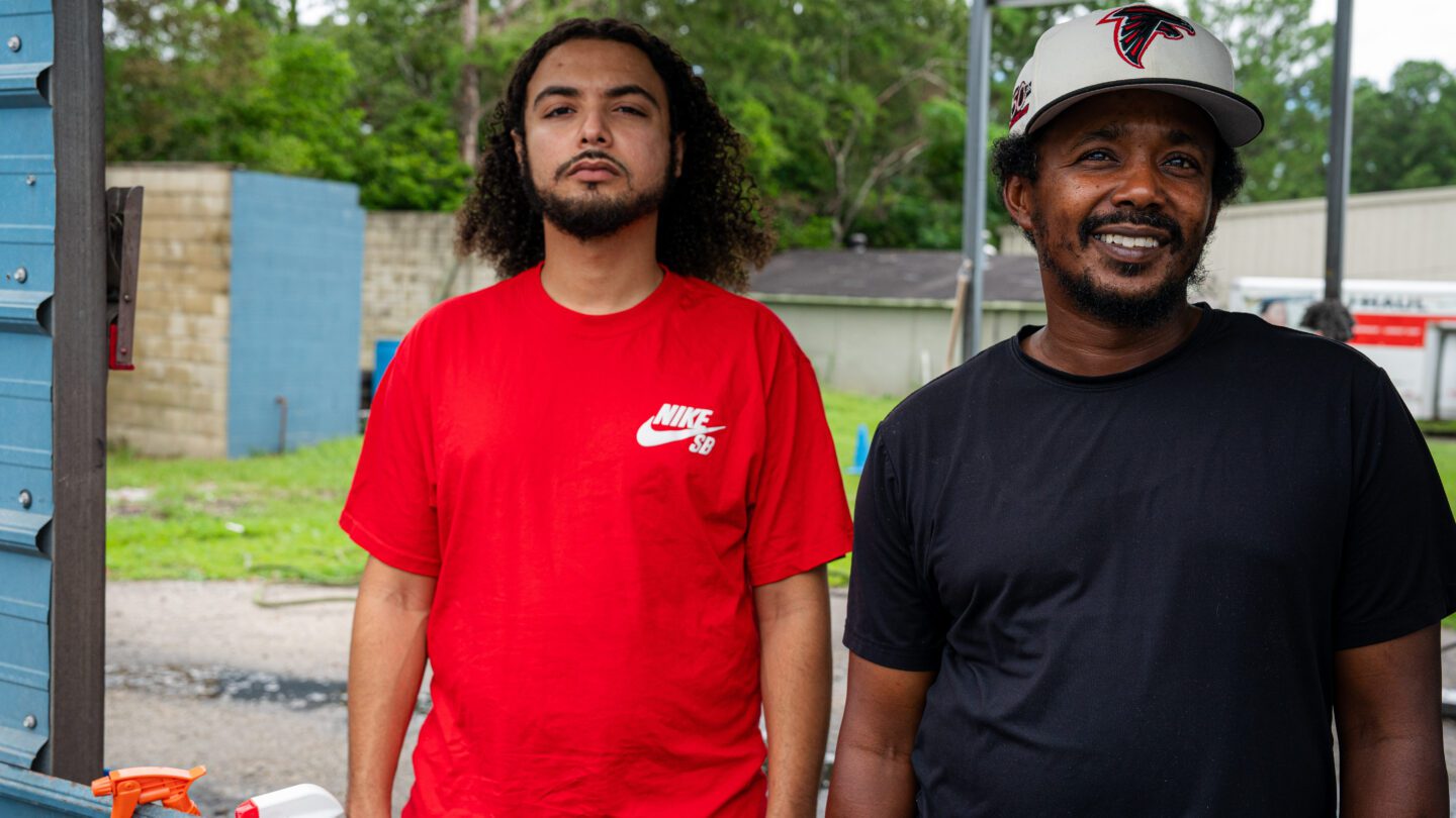 Brothers Adam Davis (left) and Broderick Godbee (right) post for a photo at Godbee's car wash in Augusta.