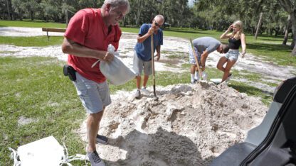 Roger Heim, left, and Terry Smith, second from left, both of Valrico, Fla., fill sand bags in preparation for a weekend storm at the Edward Medard Conservation Park in Plant City,