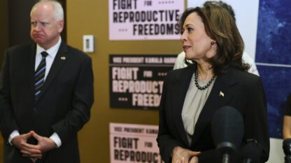 Minnesota Governor Tim Walz listens to Vice President Kamala Harris speak at Planned Parenthood.