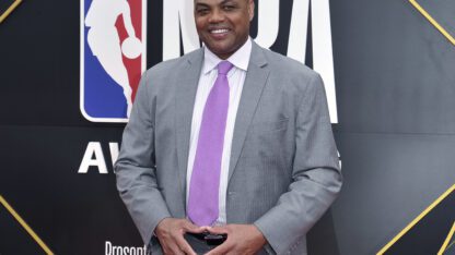 Charles Barkley stands for photos at the NBA Awards, wearing a purple tie.