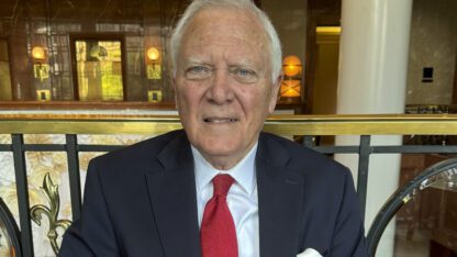 Former Georgia Gov. Nathan Deal poses for a photo against a black and gold railing.