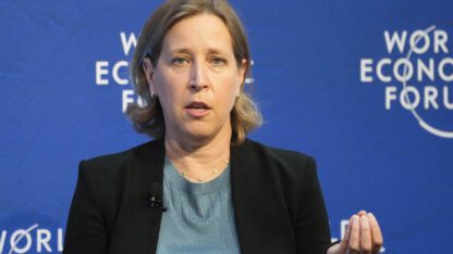 YouTube CEO Susan Wojcicki speaks during a conversation at the World Economic Forum in Davos, Switzerland. She speaks in front of a blue background with the words World Economic Forum on it.