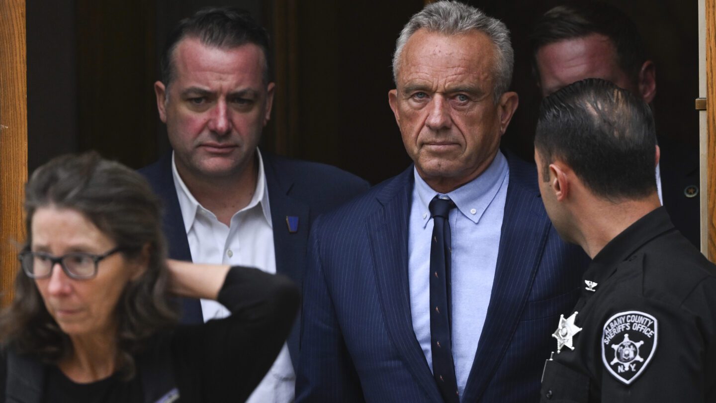 Robert F. Kennedy Jr. exits a courthouse surrounded by others.