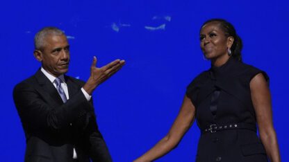 Barack Obama holds Michelle Obama's hand at the 2024 Democratic National Convention in Chicago after her speech.