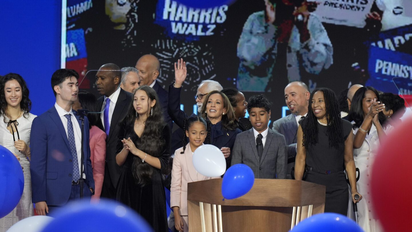 Democratic presidential nominee Vice President Kamala Harris, center, hugs her grand-niece Amara Ajagu surrounded by family during the Democratic National Convention Thursday, Aug. 22, 2024, in Chicago.