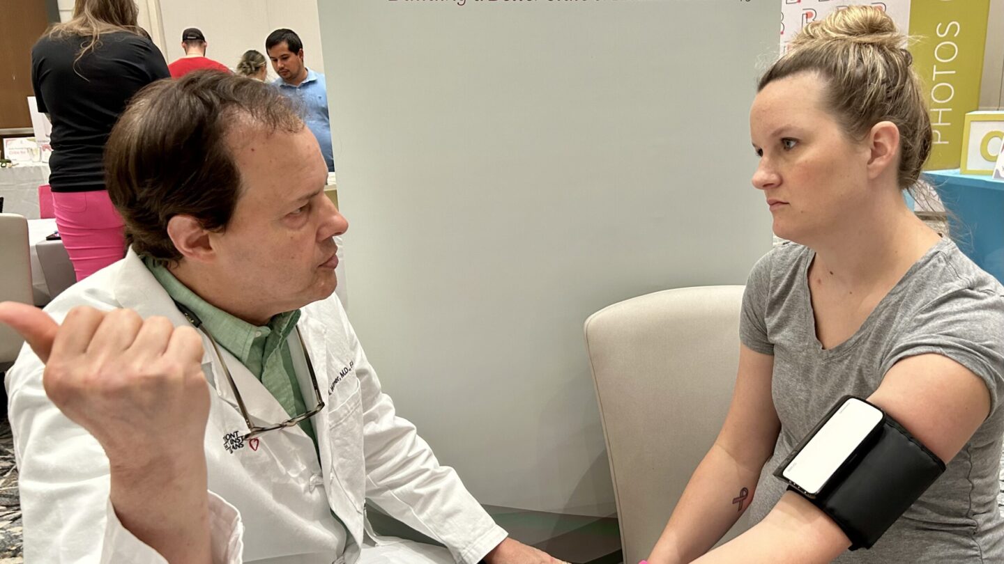 Dr. Charles Wilmer, President of the Medical Association of Georgia and a Cardiologist at Piedmont Heart Institute, gives Katie Poole a blood pressure test. Poole had high blood pressure and developed preeclampsia during a previous pregnancy. (WABE/Jess Mador)