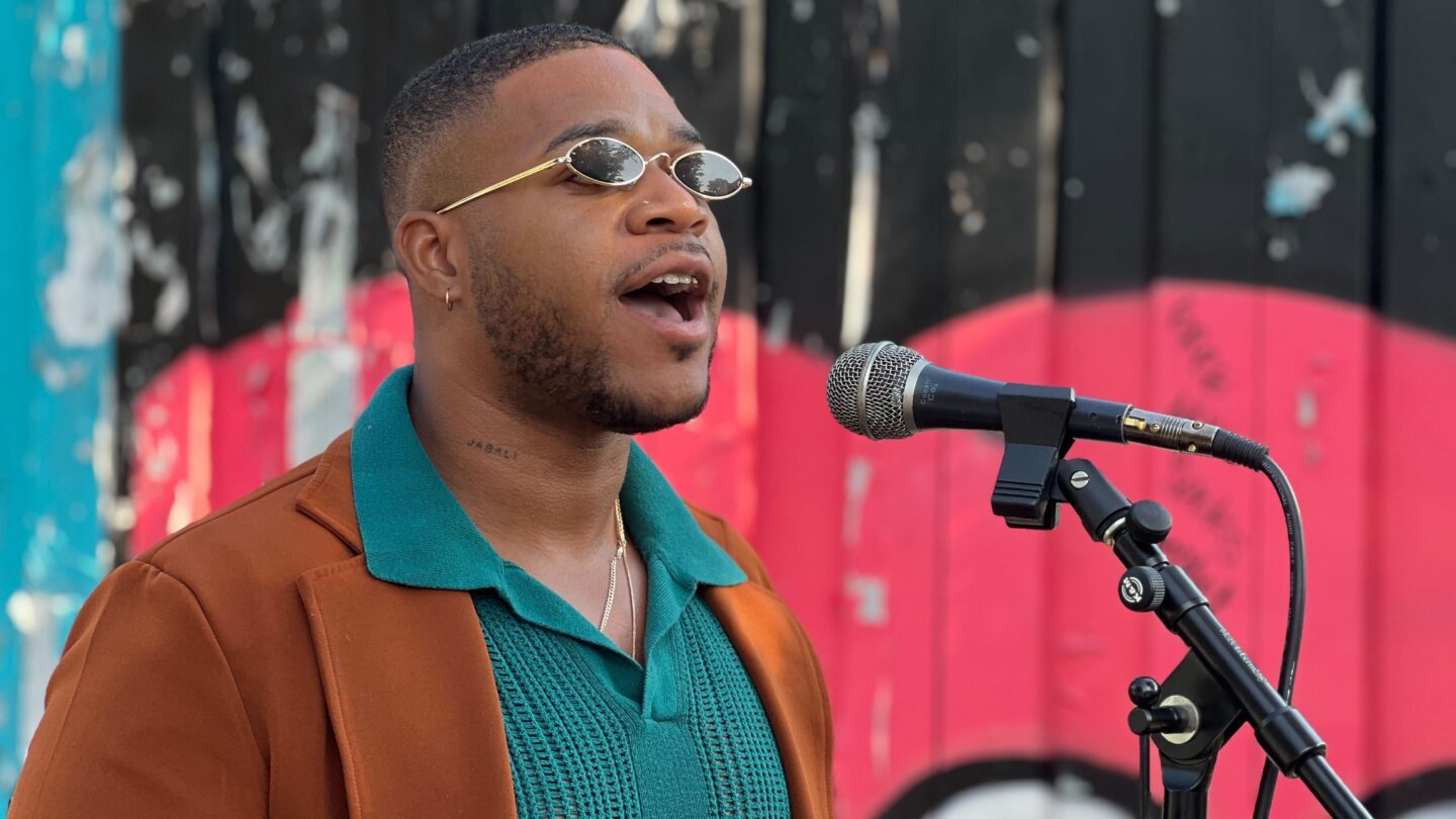 Devin Barrington-Ward speaks at a rally into a microphone.