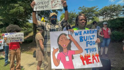 A group of people are waving signs asking for better working conditions and improved heat safety.