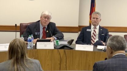 Bill Cowsert sits on the left at a long desk, facing several Fulton County officials during a Georgia Senate hearing.