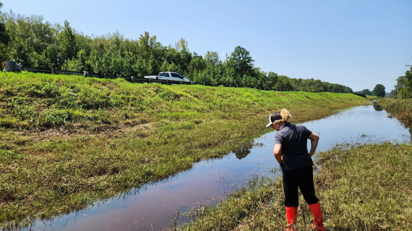 Jill Nagel with the Georgia Department of Transportation surveys a drainage ditch with a high water level along Route 301 near Statesboro.