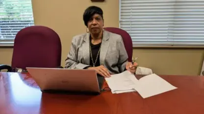 Former Stone Mountain City Manager Darnetta Tyus sits at her desk in front of a laptop and some papers.