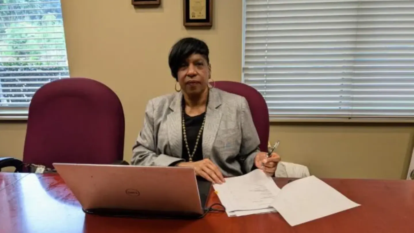 Former Stone Mountain City Manager Darnetta Tyus sits at her desk in front of a laptop and some papers.