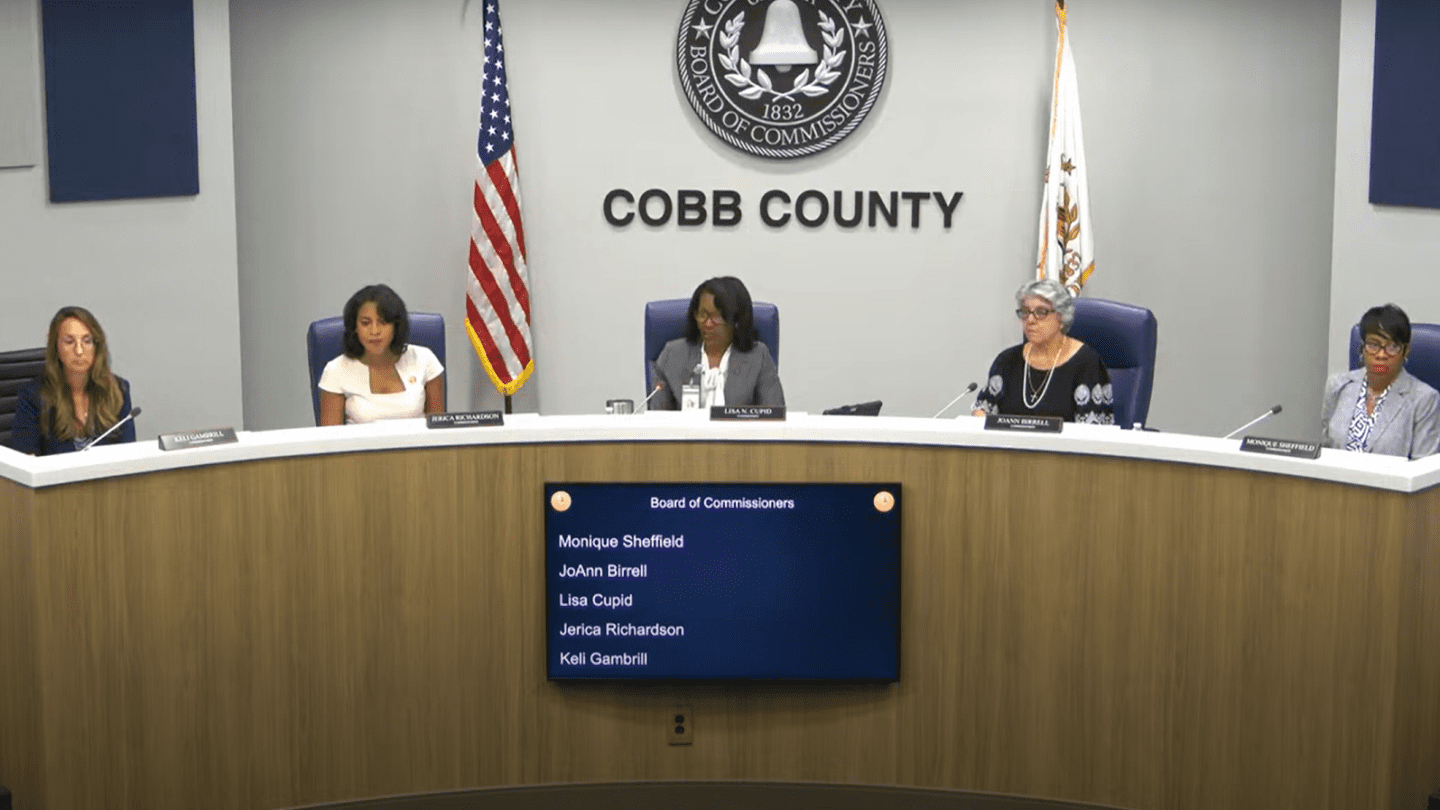 Five commissioners sit at a long table for the Cobb County Commission meeting.